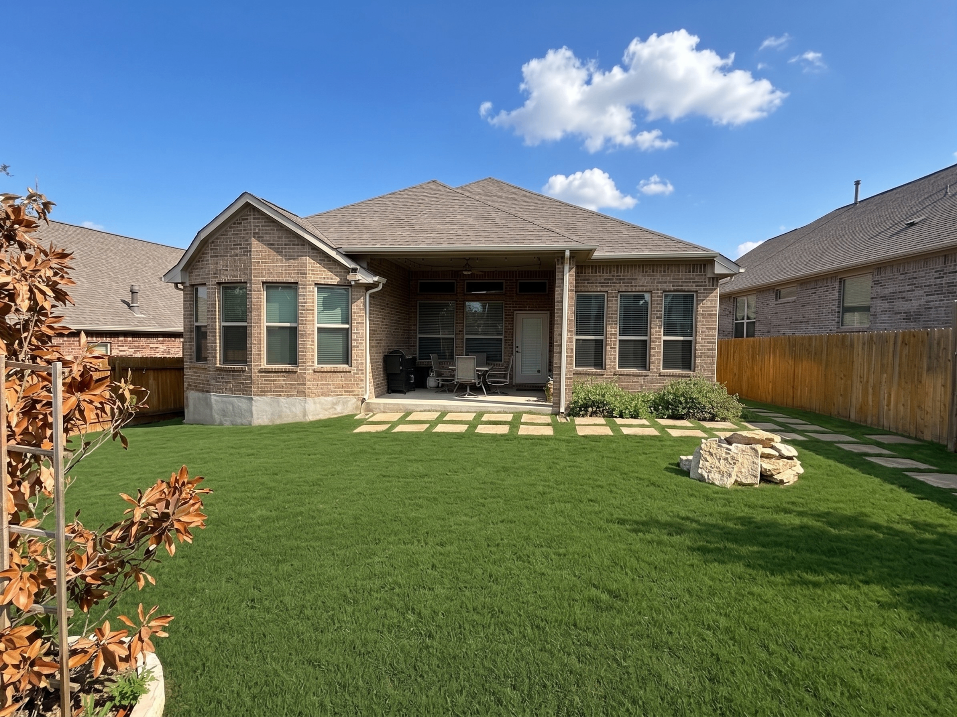 Backyard with covered Texas patio, lawn and privacy-fenced yard